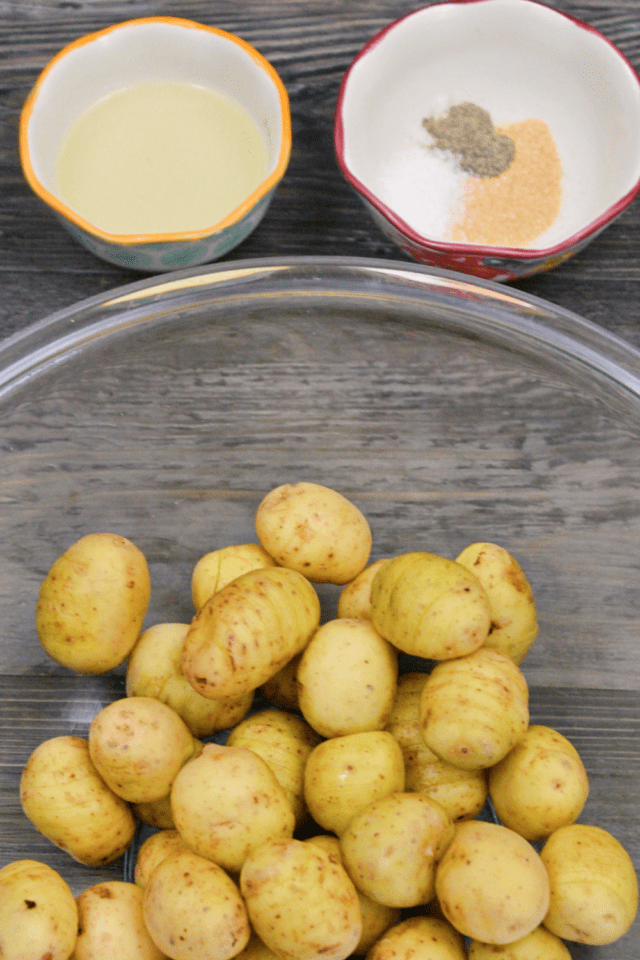 A bowl of potatoes pictures with little bowls of coconut oil and seasonings.