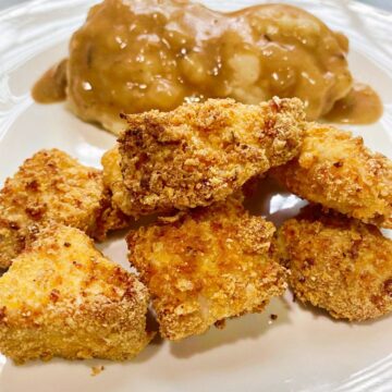 Golden Brown Chicken Nuggets plated with mashed cauliflower and gravy.