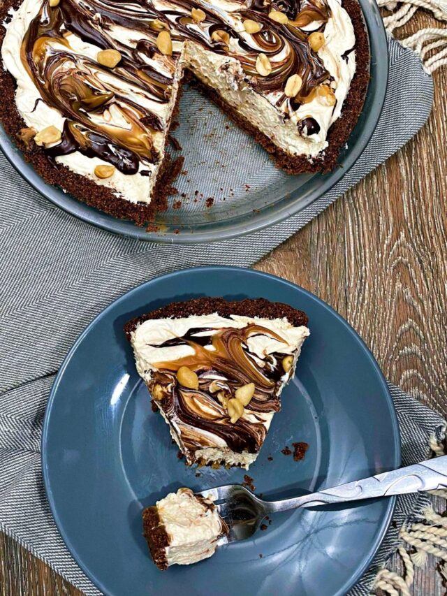A slice of Snickers Pie on a gray plate with the whole pie missing a slice to the top left.