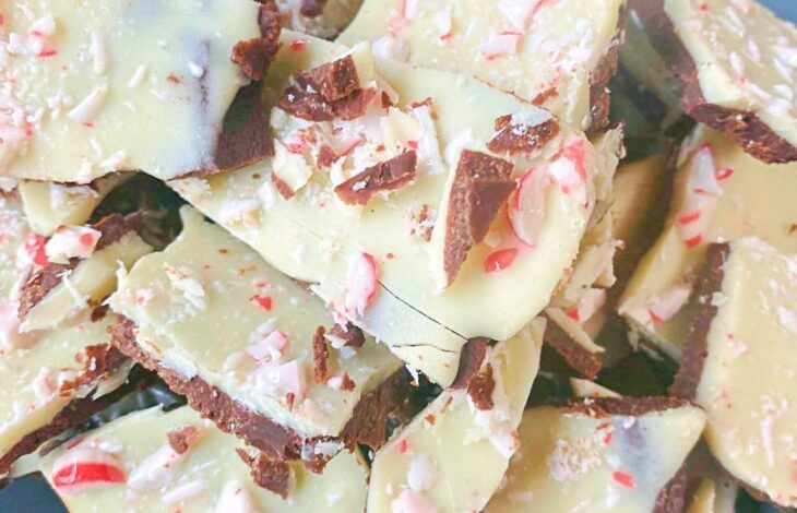 A stack of peppermint bark. A chocolate bottom layer with a white chocolate top layer and peppermint pieces.