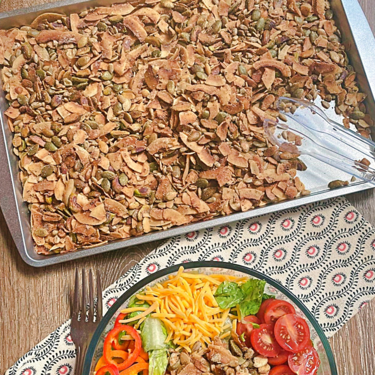 A silver baking sheet full of the toasted salad toppers.