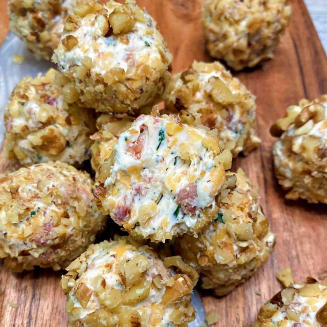 A stack of Mini Bacon Cheddar Ranch Cheese Balls with a bite taken out of the center one.