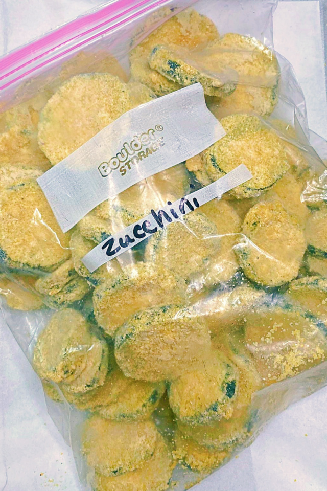 A top down photo of a freezer bag full of breaded and frozen summer squash. 